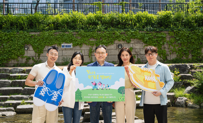 지난달 27일 서울시 종로구 청계천에서 ‘빛나는한걸음’ 캠페인에 참여한 직원들이 기념 촬영을 하고 있다. 사진/신한라이프