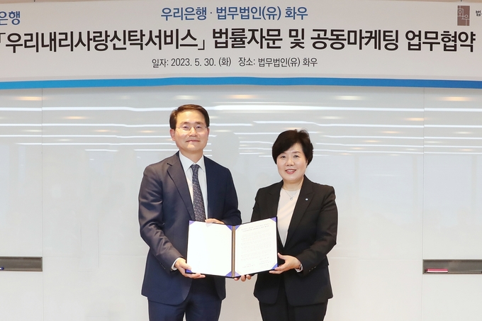 송현주 우리은행 자산관리그룹장(오른쪽)과 법무법인(유) 화우 이명수 대표 변호사가 기념촬영을 하고 있다. 사진제공/우리은행