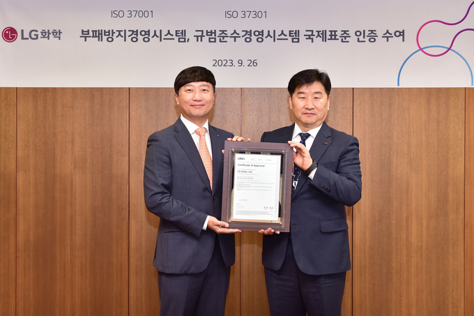 이규호 LG화학 법무실장(사진 왼쪽)이 26일 여의도 LG트윈타워에서 이일형 로이드인증원 대표이사로부터 컴플라이언스 및 부패방지 경영시스템 국제표준인증서를 수여 받은 뒤 기념촬영을 하고 있다. @LG화학