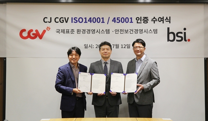 CJ CGV 황재현 전략지원담당(좌), 최재혁 안전경영담당(우)과 BSI KOREA 임성환 대표이사(가운데)가 지난 7월 12일 CJ CGV 본사에서 진행된 'ISO14001', 'ISO45001' 인증서 수여식이 끝난 후 기념사진을 찍고 있는 모습. @ CGV