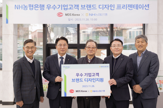 경기 파주시 소재 MDS코리아에서 열린 브랜드 디자인 지원 현판식 행사에서 이석용 농협은행장(왼쪽 두번째), 문동준 MDS코리아 대표이사(가운데) 및 임직원들이 기념촬영을 하고 있다. @농협은행