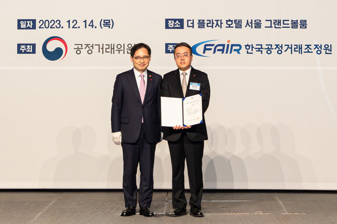 롯데건설 준법경영부문 조도휘 상무(사진 오른쪽)가 한기정 공정거래위원장(사진 왼쪽)으로부터 우수기업 평가증을 수여한 후 기념 촬영을 하고있다. @롯데건설