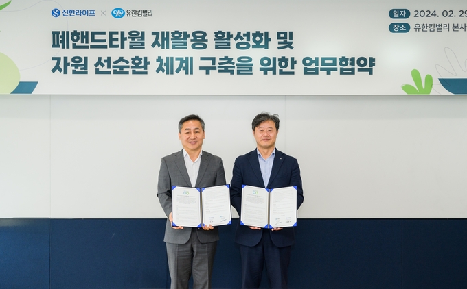 서울 송파구 유한킴벌리 사옥에서 열린 업무협약식에서 김순기 신한라이프 전략기획그룹장(오른쪽)과 손승우 유한킴벌리 지속가능경영부문 부문장(왼쪽)이 기념촬영을 하고 있다.>@신한라이프