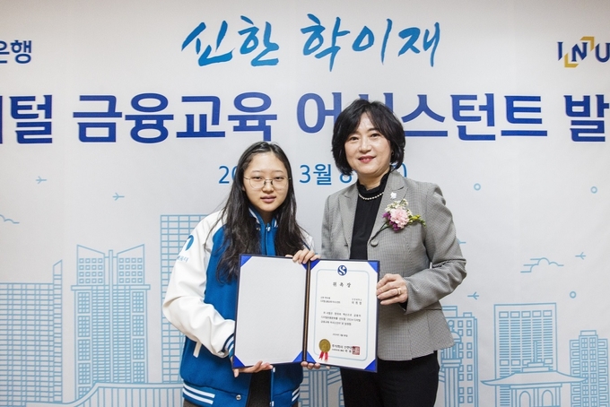 지난 8일 인천시 남동구 소재 금융소비자 교육센터 ‘신한 학이재’에서 ‘신한 학이재 디지털 금융교육 어시스턴트’ 발대식을 개최하고 신한은행 소비자보호그룹 박현주 부행장(오른쪽)과 어시스턴트 대표 학생이 기념 촬영 하고 있는 모습. @신한은행