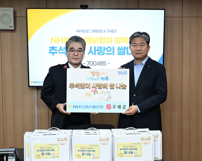 농협손보 강필규 경영기획부문 부사장(사진 오른쪽)과 구세군 박종환 커뮤니케이션부장(사진 왼쪽)이 기념사진 촬영을 하고 있다. 사진/농협손보