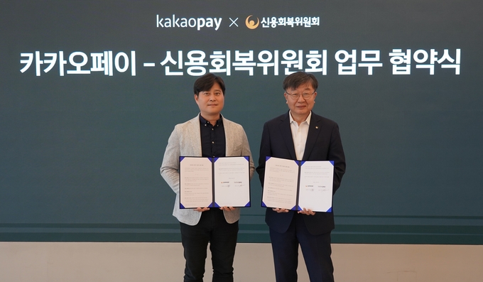 신원근 카카오페이 대표(왼쪽)와 이재연 신용회복위원회 위원장(오른쪽)이 지난 24일 경기도 판교 카카오페이 오피스에서 제휴 협약식을 진행한 뒤 기념촬영을 진행하고 있다. 사진/카카오페이