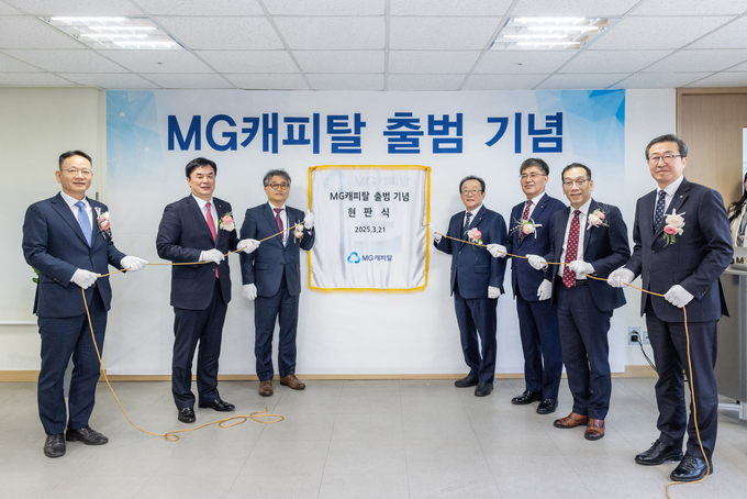 김인 새마을금고중앙회장(오른쪽 네번째)과 김병국 신임 대표이사(왼쪽 세번째)가 지난 21일 서울 강남구 MG캐피탈 사옥에서 개최된 현판식에서 참석자들과 기념 촬영을 하고 있다. 사진/새마을금고중앙회