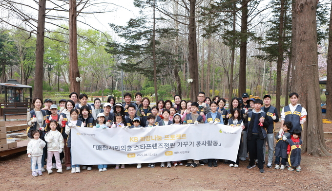 지난 12일 서울시 서초구 매헌시민의숲에 위치한 ‘KB국민은행 스타프렌즈정원’에서 진행한 봄 맞이 환경정비 봉사활동에서 KB국민은행 임직원 및 가족이 기념촬영을 하고 있다. 사진/ KB국민은행