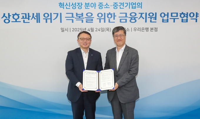 우리은행은 지난 24일 우리은행 본점에서 신용보증기금과 상호관세위기 극복을 위한 금융지원 업무협약을 체결했다. 우리은행 정진완 은행장(왼쪽)과 최원목 신용보증기금 이사장이 기념촬영을 하고 있다. 사진/우리은행