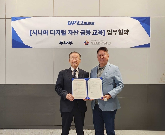 두나무가 세대별 디지털 자산 교육프로그램 업클래스(UP Class) 론칭에 앞서 금융위원회 산하 비영리 법인 시니어금융교육협의회와 공동업무협약(MOU)을 체결했다. 사진 왼쪽은 윤덕홍 시교협 회장, 오른쪽은 이석우 두나무 대표. 사진/두나무