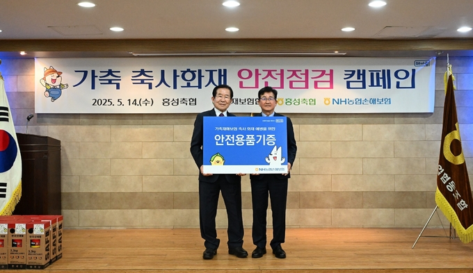 송춘수 대표이사(사진 오른쪽)가 이대영 조합장(사진 왼쪽)에게 화재예방 안전용품 기증 후 기념촬영을 하고 있다. 사진/ 농협손해보험