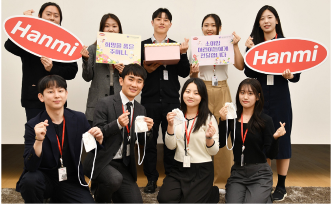 한미사이언스와 한미약품 직원들이 소아암 환아를 위한 응원의 마음을 담아 손수 제작한 ‘히크만 주머니’를 들고 기념촬영을 하고 있다. 사진/한미그룹
