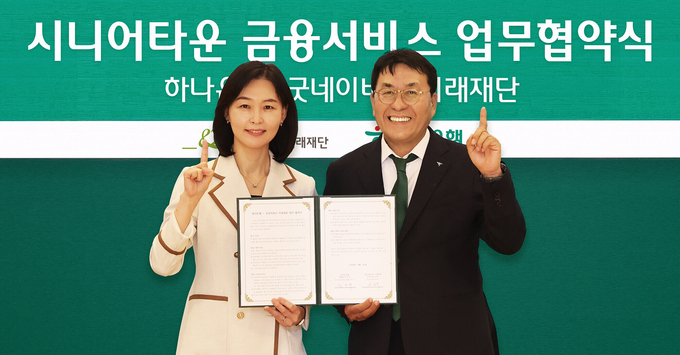 이날 협약식에 참석한 김진우 하나은행 중앙영업그룹 부행장(사진 오른쪽)이 양진옥 굿네이버스 미래재단 대표(사진 왼쪽)와 함께 업무협약서를 들고 기념 촬영을 하고 있다. 사진/ 하나은행