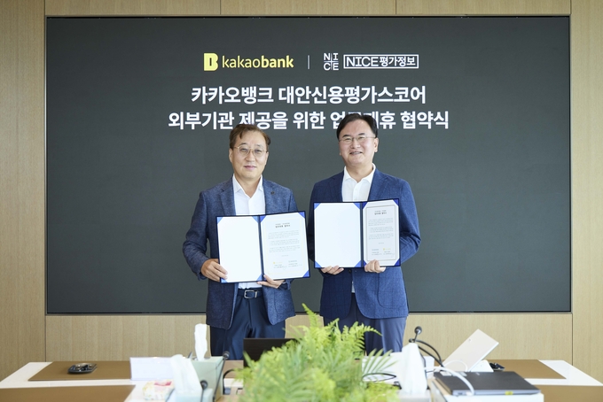 윤호영 카카오뱅크 대표이사(왼쪽)와 김종윤 NICE평가정보 대표이사(오른쪽)가 30일 경기도 성남시 카카오뱅크 판교오피스에서 진행된 업무협약 체결식에서 기념촬영을 하고 있다. 사진/카카오뱅크