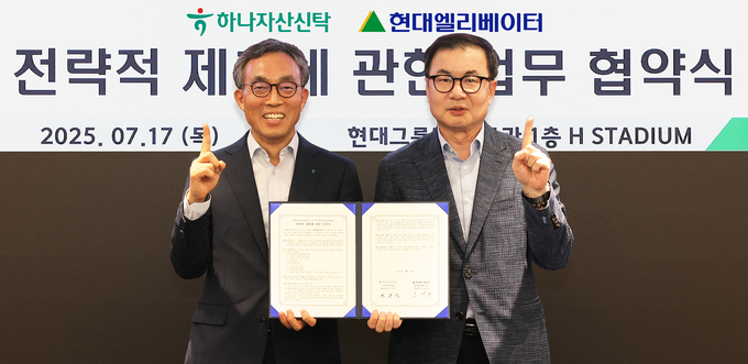 협약식에 참석한 민관식 하나자산신탁 대표이사(사진 왼쪽)가 조재천 현대엘리베이터 대표이사(사진 오른쪽)와 함께 협약서를 들고 기념촬영을 하고 있다. 사진/하나자산신탁