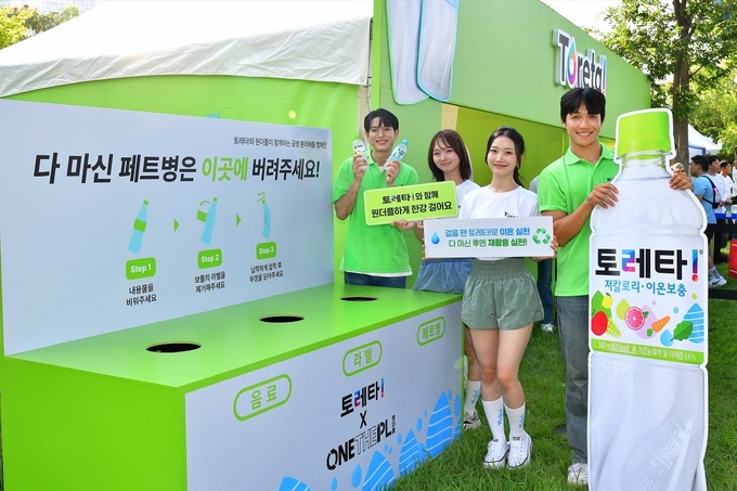 코카-콜라사의 이온보충음료 토레타!가 2일과 3일 양일간 서울 여의도 한강공원 녹음수광장에서 진행된 ‘2025 한강나이트워크42K With 토레타!’에서 모델들이 토레타! ‘원더플 수거함’ 앞에서 올바른 페트병 분리배출 방법을 안내하고 있다 (사진제공=한국코카-콜라)