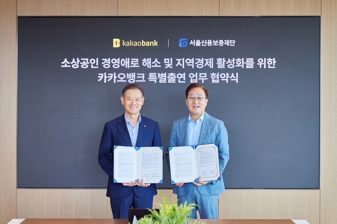 카카오뱅크 윤호영 대표이사(오른쪽)와 최항도 서울신용보증재단 이사장(왼쪽)이 지난 25일 경기도 성남시 카카오뱅크 판교오피스에서 진행된 '카카오뱅크 특별출연 업무 협약식'에 참석해 기념 촬영을 하고 있다. 사진/카카오뱅크