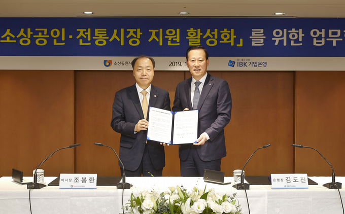 13일 ‘소상공인·전통시장 지원 활성화를 위한 업무협약식’을 마치고 김도진 IBK기업은행 은행장(오른쪽), 조봉환 소상공인시장진흥공단 이사장(왼쪽)이 기념촬영을 하고 있는 모습.   사진/기업은행 